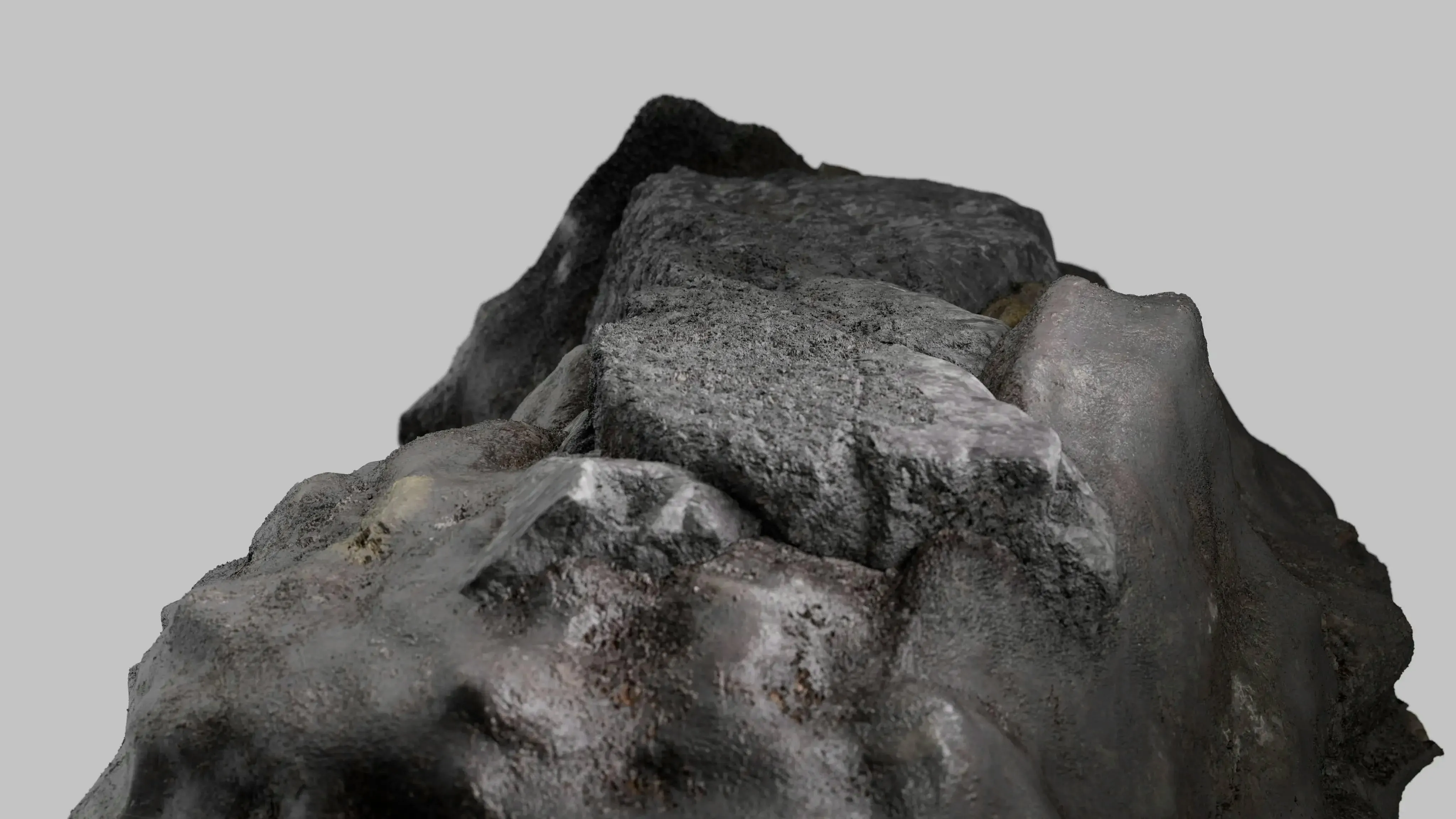 A piece of uraninite (a major uranium ore mineral) floating on a grey background. 